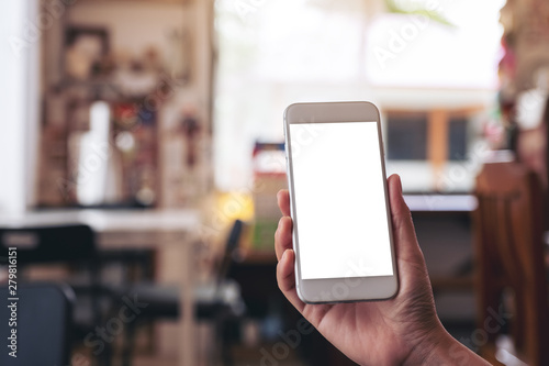 Mockup image of a woman's hand holding white mobile phone with blank desktop screen