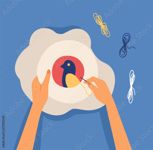 Hands embroidering craft hoop bird