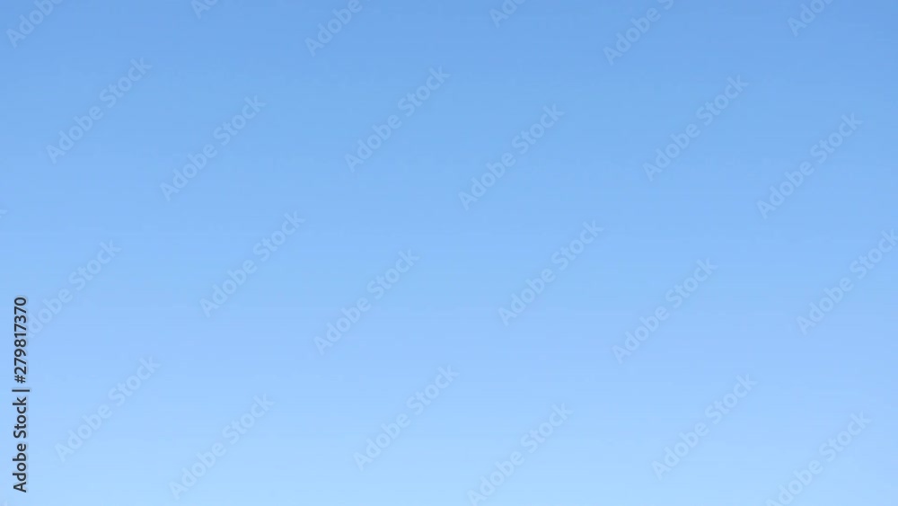 Airplane jet flying overhead against blue summer sky Airplane jet flying overhead against blue summer sky