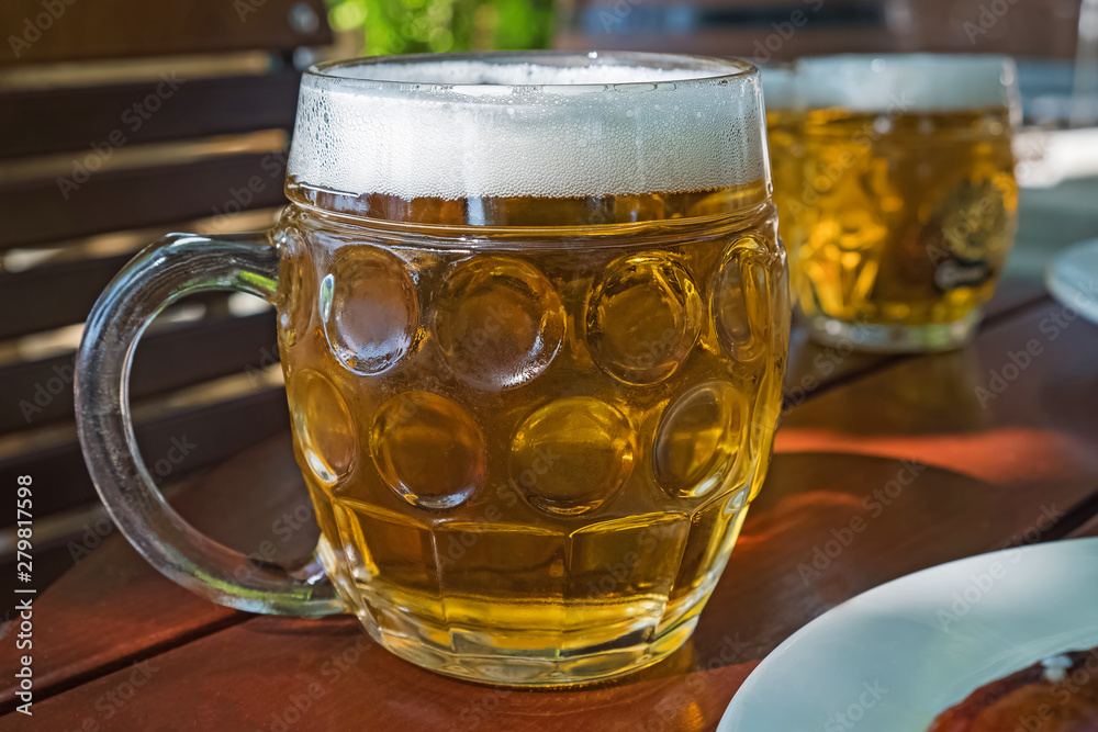 Traditional beer mug with light lager beer in a street caffee Traditional beer mug with light lager beer in a street caffee