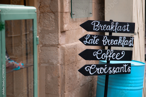 Breakfast, Coffee, Croissant sign on buisy european street
