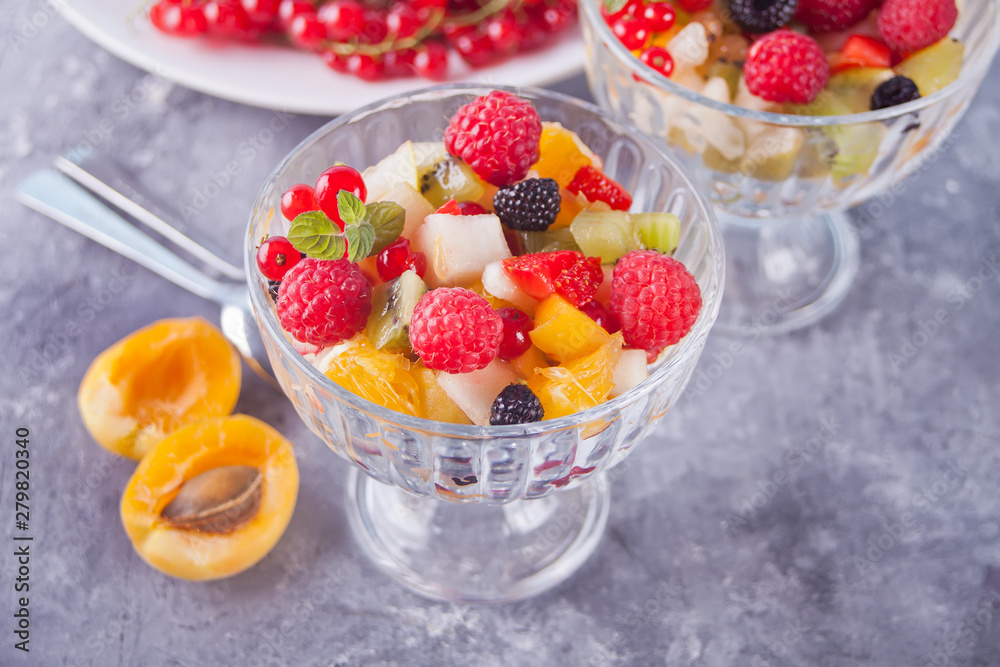 salad with fresh fruits and berries on a bowls on the concreate background