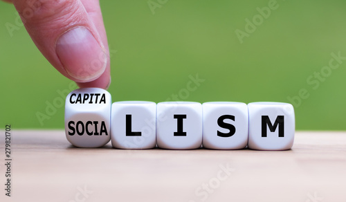 Tableau sur toile Hand flips a dice and changes the word Socialism to Capitalism, or vice versa