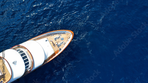 Aerial drone photo of luxury yacht with wooden deck in deep blue sea of iconic island of Mykonos near super Paradise beach, Cyclades, Greece