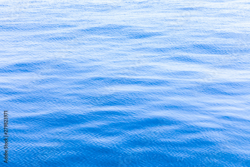 Fotografi The background or texture of the blue water surface of the river, lake or sea wi