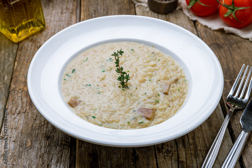 risotto with porcini mushrooms on wooden table risotto with porcini mushrooms on wooden table