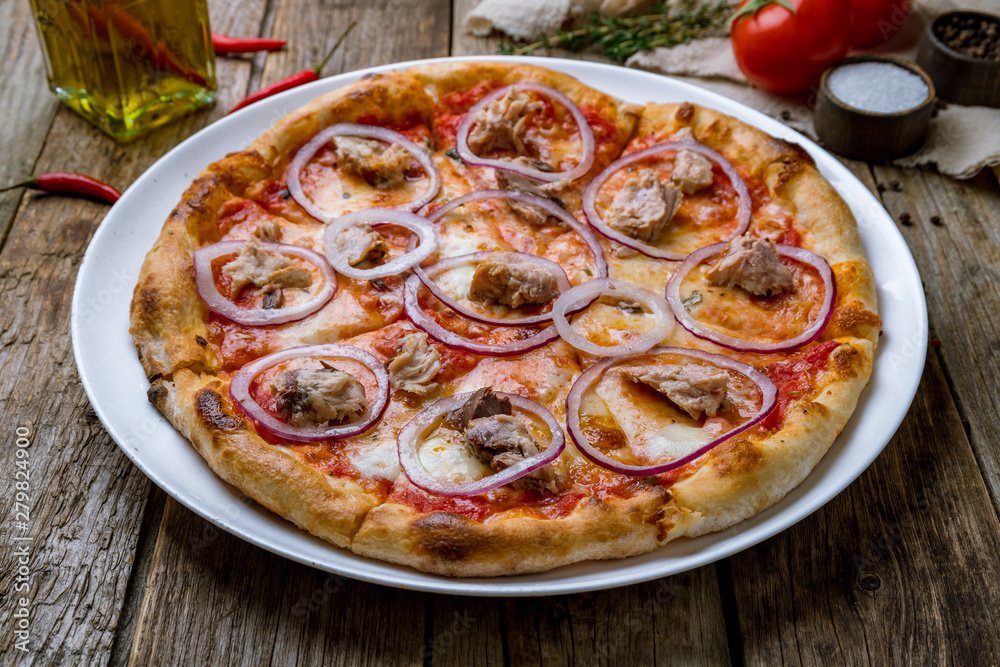 Pizza with tuna and red onion on wooden background
