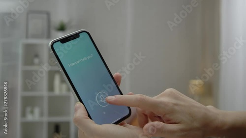 Woman is using intelligent voice assistant on smartphone. Shot on RED film camera.