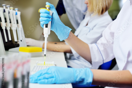 A scientist in a medical laboratory with a dispenser in his hands is doing an analysis