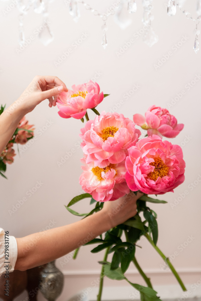 Hands of a young florist woman making modern bouquet of flowers