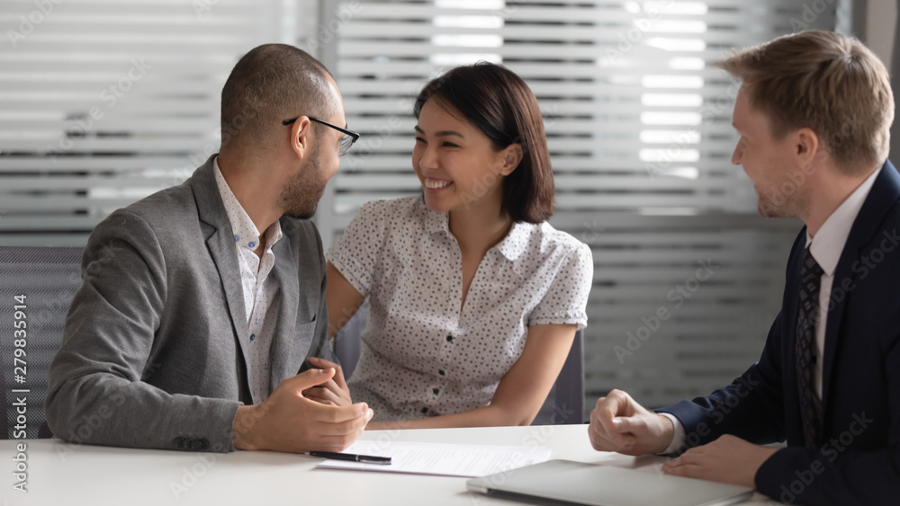 Excited mixed ethnicity couple customers decide on making business deal Excited mixed ethnicity couple customers decide on making business deal