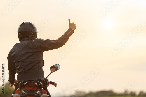 Valokuva Handsome motorcyclist wear leather jacket and holding helmet on the road