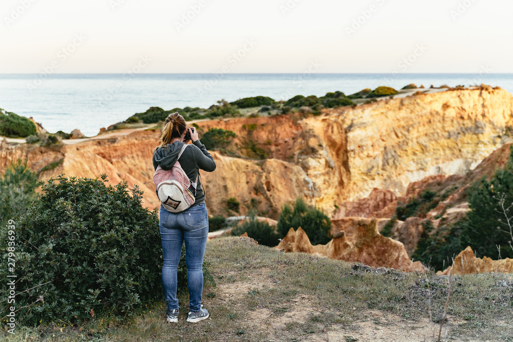 Young woman photographing limestone cliffs