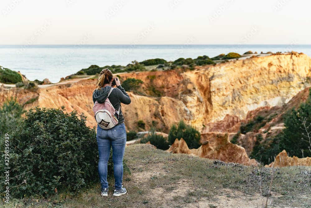 Young woman photographing limestone cliffs Young woman photographing limestone cliffs