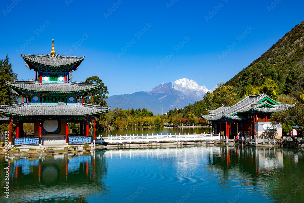 Fototapeta premium Black Dragon Pond, popular place of natural scenery near the Old Town of Lijiang on the background Jade Dragon Snow Mountain. Lijiang, China