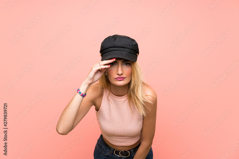 Young blonde woman with hat looking far away with hand to look something Young blonde woman with hat looking far away with hand to look something