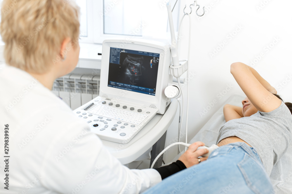 Obraz premium The doctor is preparing to conduct ultrasound research. smears the gel ultrasonic sensor