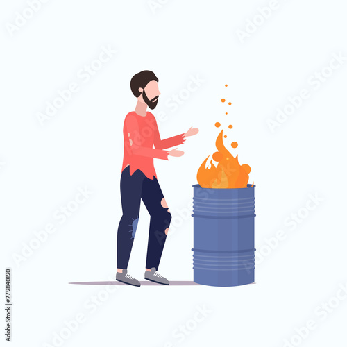 poor man warming by fire beggar guy standing near burning garbage in barrel homeless jobless concept flat full length