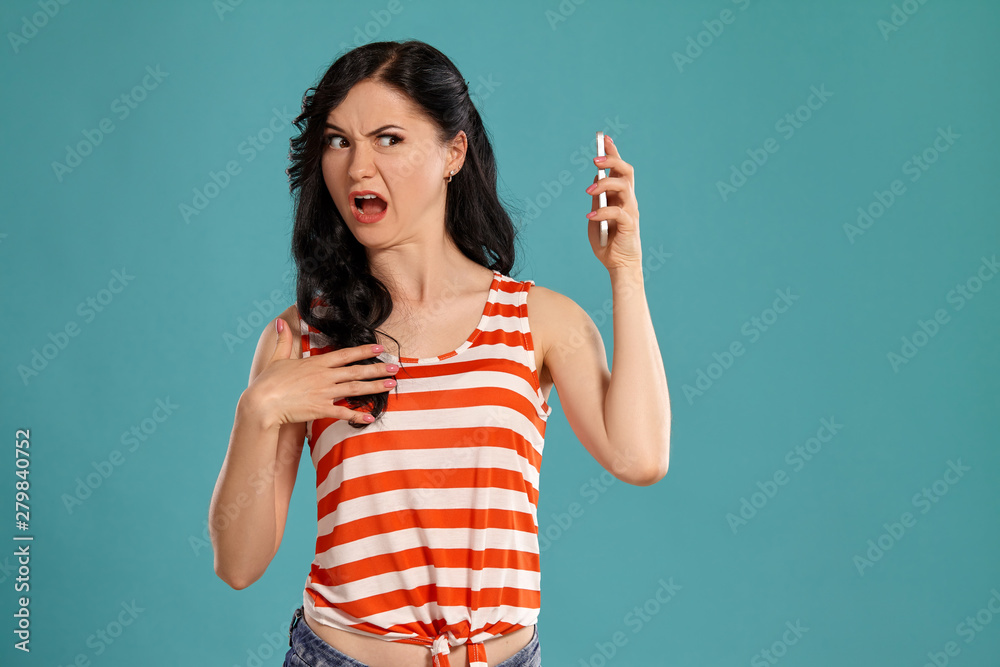 Studio photo of a gorgeous girl teenager posing over a blue background. Studio photo of a gorgeous girl teenager posing over a blue background.