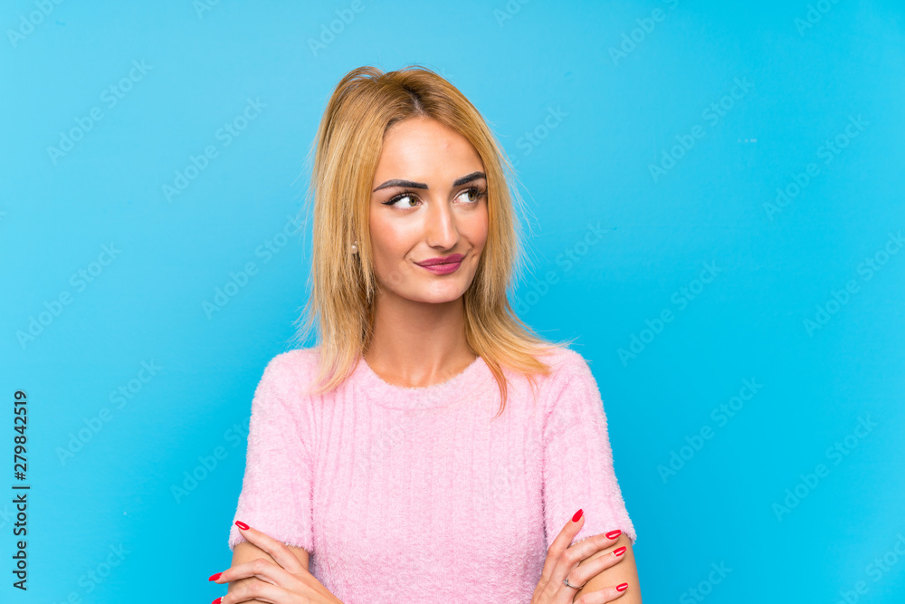 Young blonde woman over blue background thinking an idea Young blonde woman over blue background thinking an idea