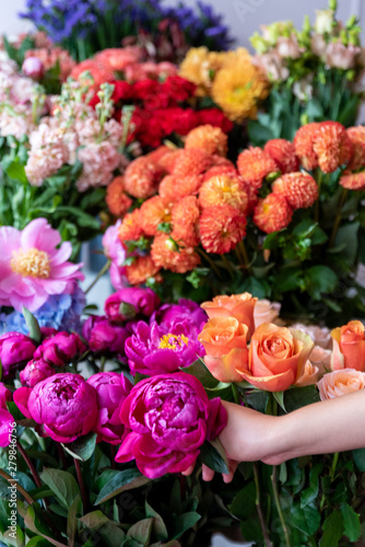 woman Hands making modern bouquet of different flowers