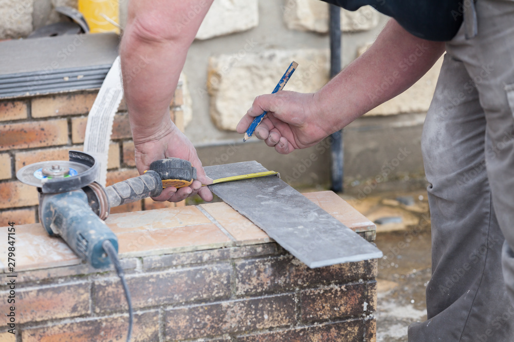 the tiler measures and puts marks to cut and lay a tile the tiler measures and puts marks to cut and lay a tile