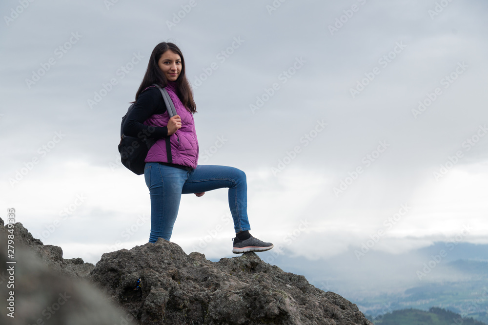 Hispanic woman backpacker tourist standing on top of the mountain - woman climbing