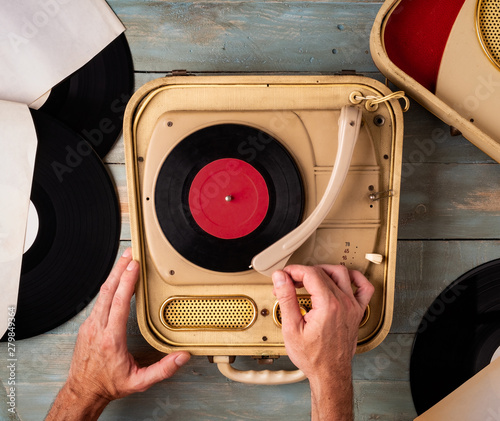 man hands switching on turntable on wooden background