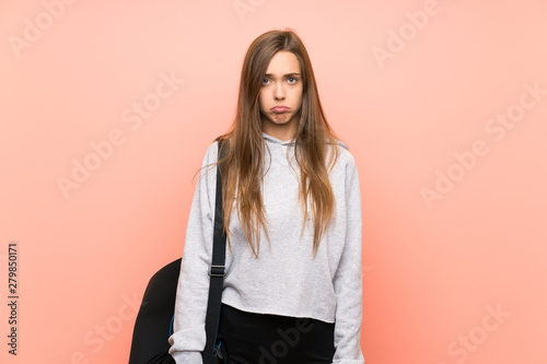 Young sport woman over isolated pink background sad © luismolinero