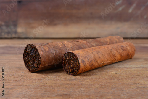 Cigars on wooden background © shahrilkhmd