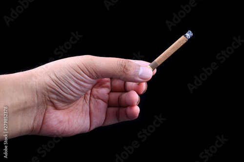 Hand holding cigar on black background