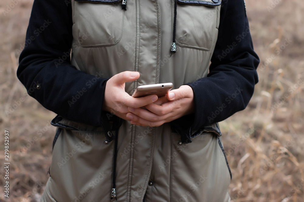 Outing. A woman is trying to find a route in the smartphone. Navigation outside the city Outing. A woman is trying to find a route in the smartphone. Navigation outside the city