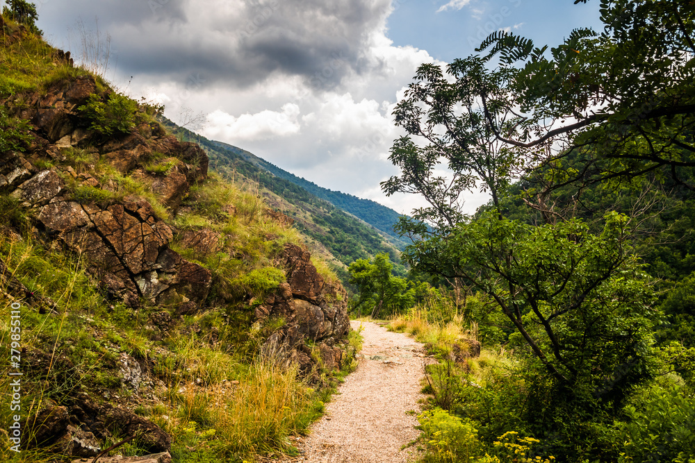 Mountain footpath through forest along the rocks. This is the path to the ruins of the medieval castle Maglic in Serbia. Mountain footpath through forest along the rocks. This is the path to the ruins of the medieval castle Maglic in Serbia.