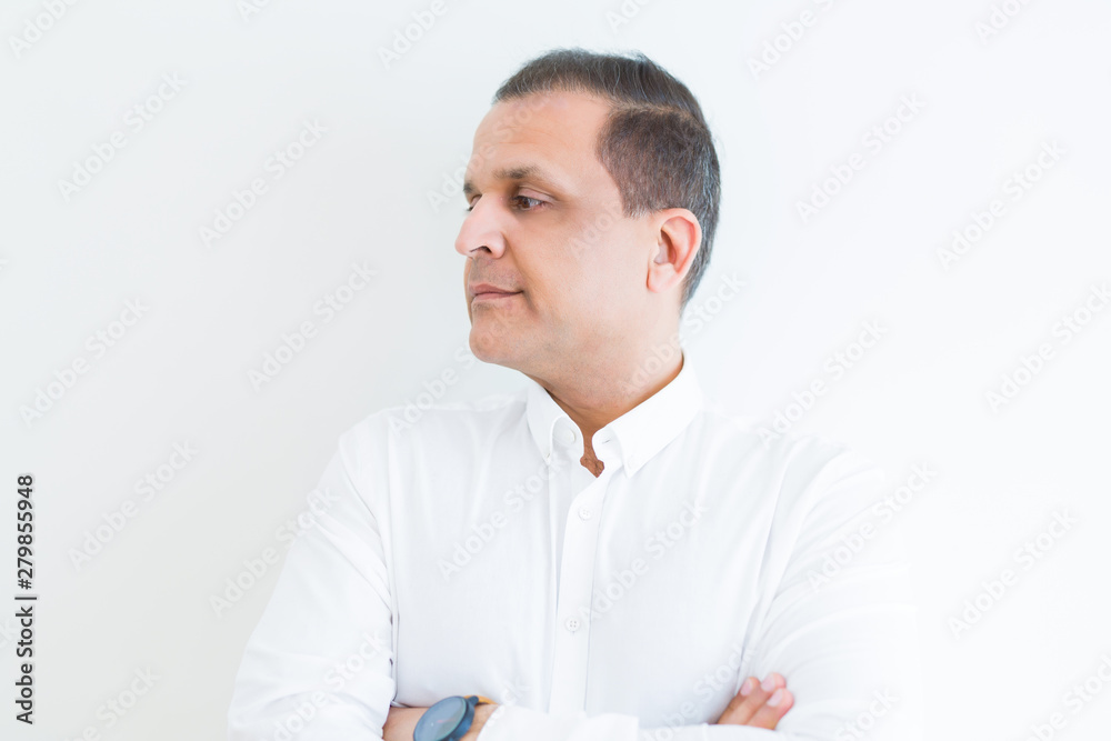 Middle age business man looking natural and relaxed with crossed arms over white wall background Middle age business man looking natural and relaxed with crossed arms over white wall background