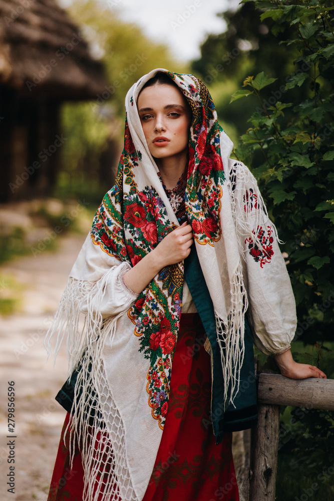 Girl in a colored Ukrainian dress poses in the park Girl in a colored Ukrainian dress poses in the park