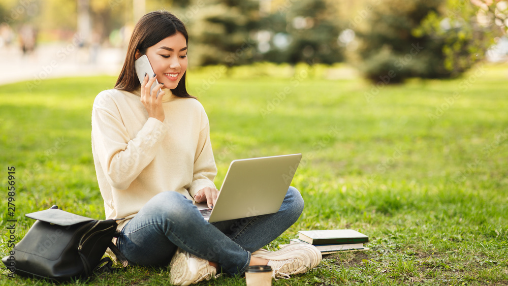 Relax after classes. Happy student sitting in park with laptop
