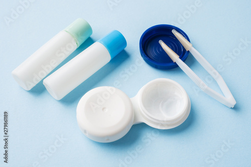 Contact lenses  tweezers and a container for storing lenses  containers for solution and moisturizing drops. Close up. Selective focus.