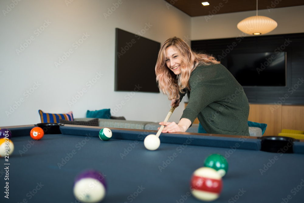© Cavan Images - Woman preparing to take her shot during game of pool © Cavan Images - Woman preparing to take her shot during game of pool