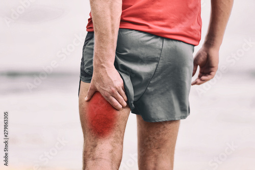 Hamstring pain pulled muscle on back thigh painful red area athlete man massaging sports injury fitness cramp muscles.