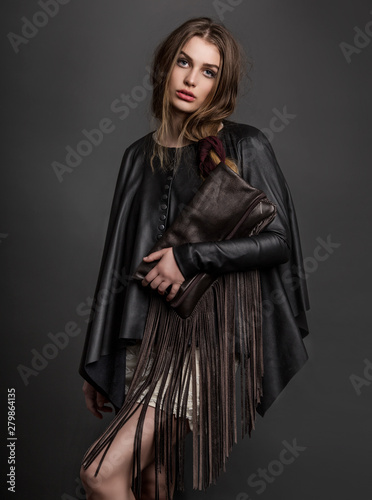 Fashion portrait of young woman wearing leather photo