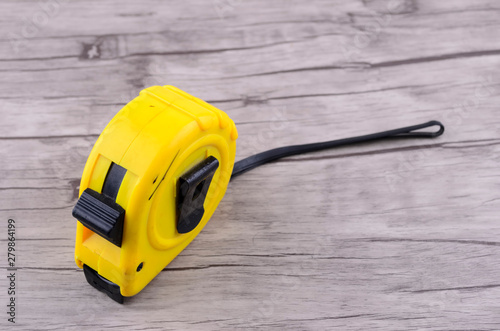yellow tape measure on wood background