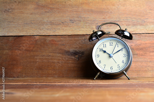 Retro alarm clock on wood background