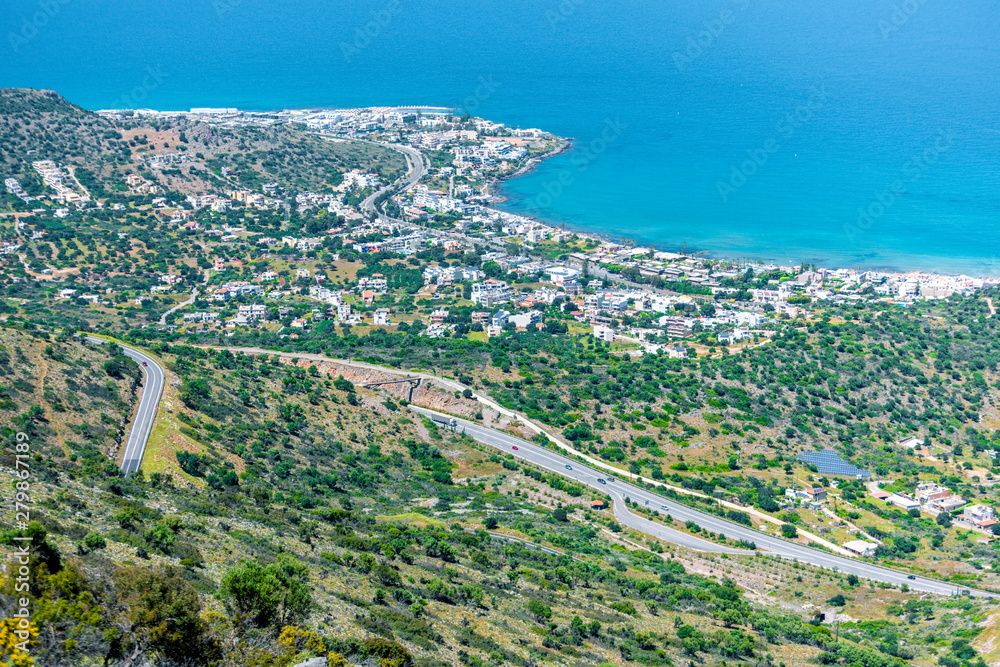 Fototapeta premium Top view from the mountains to the village of Malia, roads and the nearby villages of the field and the Aegean Sea. Crete, Greece