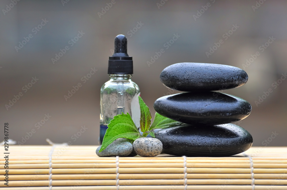 Pebble stones with spa oil on nature bokeh background - SPA Concept Pebble stones with spa oil on nature bokeh background - SPA Concept