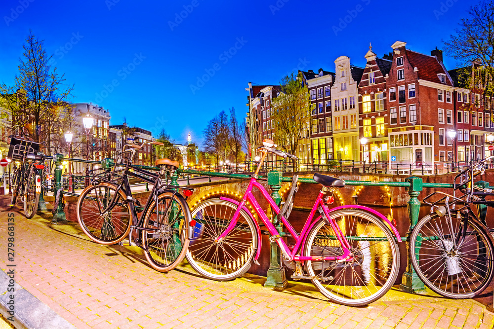 Bicycle parked on a bridge in Amsterdam at night,  Netherlands