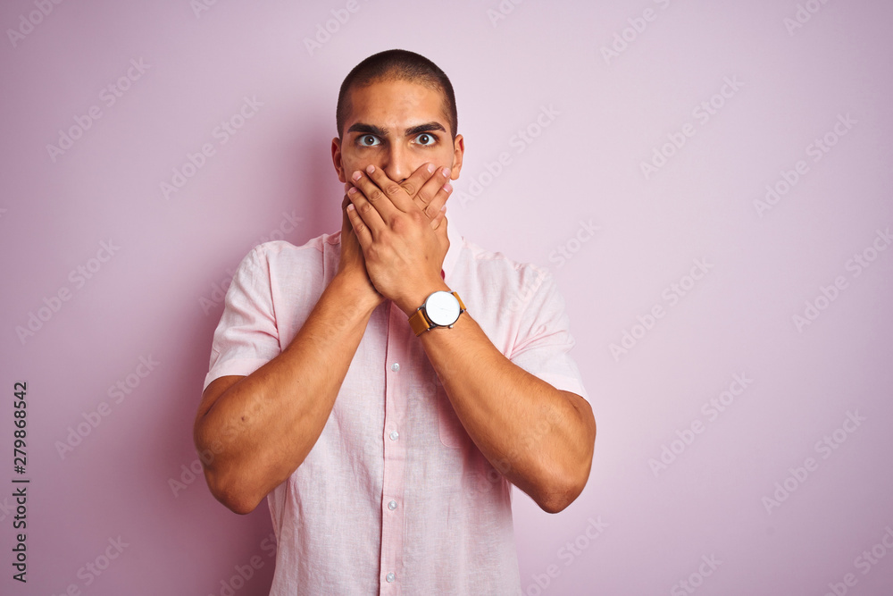 Young handsome man wearing elegant shirt over pink isolated background shocked covering mouth with hands for mistake. Secret concept. Young handsome man wearing elegant shirt over pink isolated background shocked covering mouth with hands for mistake. Secret concept.