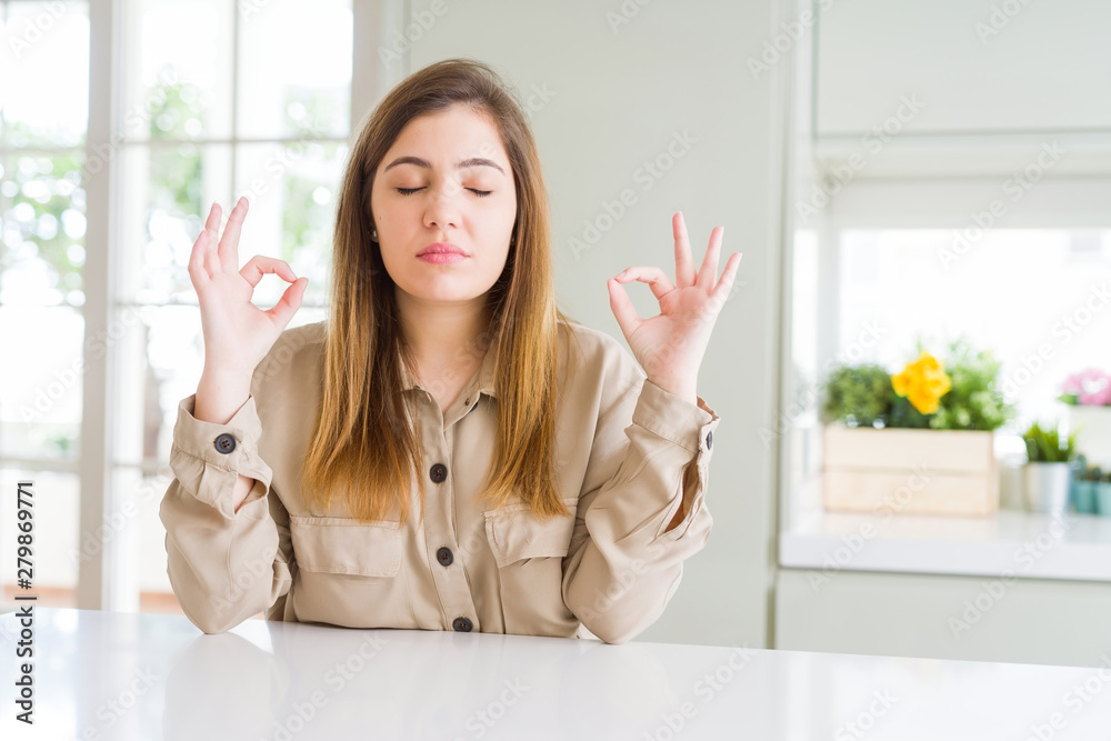 Beautiful young woman at home relax and smiling with eyes closed doing meditation gesture with fingers. Yoga concept. Beautiful young woman at home relax and smiling with eyes closed doing meditation gesture with fingers. Yoga concept.