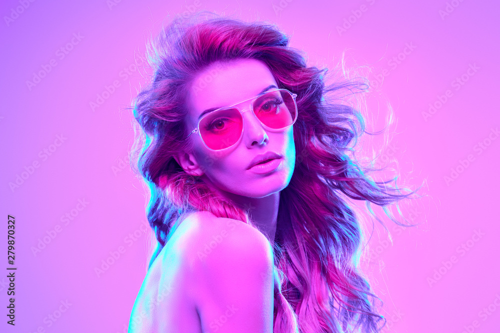 High fashion. Woman in colorful bright Neon purple light. Glamour sexy disco girl with Trendy pink hair, Stylish sunglasses, makeup. Creative fashionable neon portrait. Night Club concept