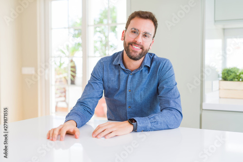 Handsome man wearing glasses and smiling relaxed at camera © Krakenimages.com