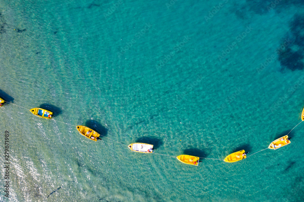 Obraz premium Aerial view of boats floating on calm sea water. Turquoise ocean seen from above.
